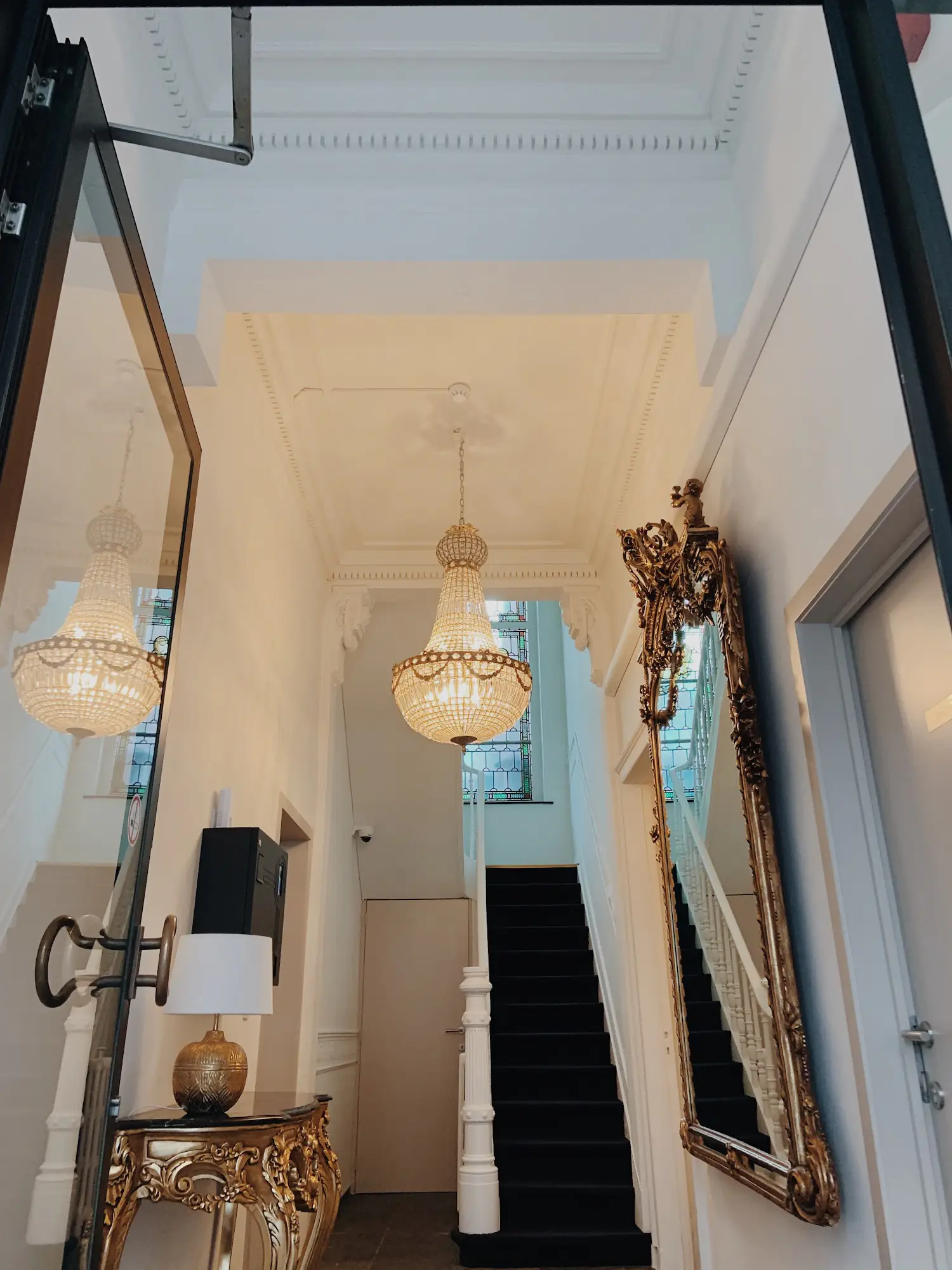 Grand crystal chandelier and gilded mirror in the elegant La Lys entryway
