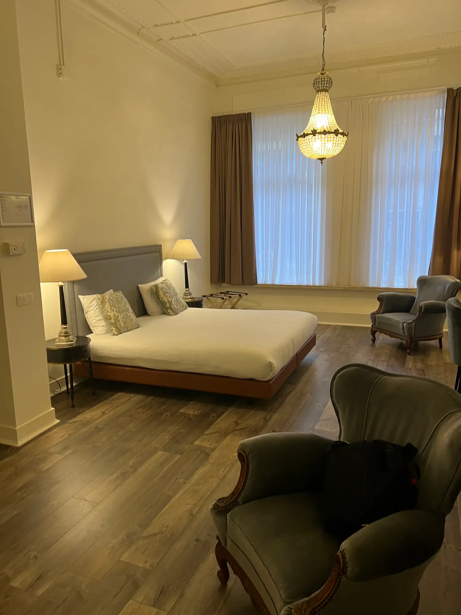 Spacious suite with crystal chandelier and comfortable seating at La Lys