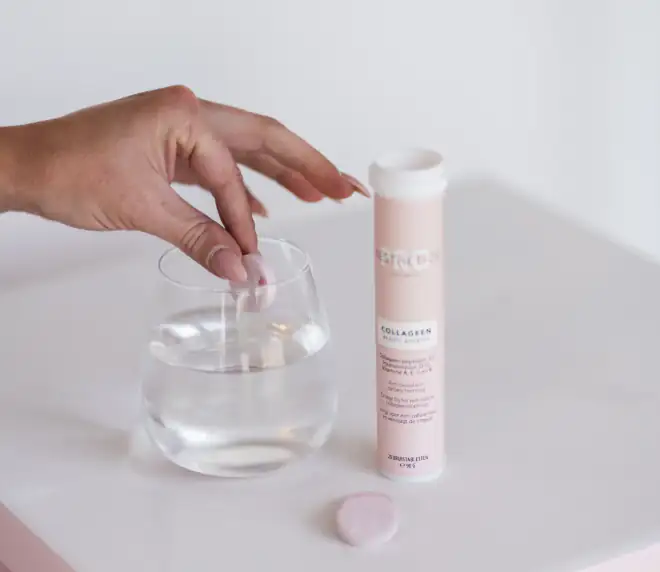 Collageen supplement bruistablet in glas water naast tube — ondersteunend voor huidresultaat