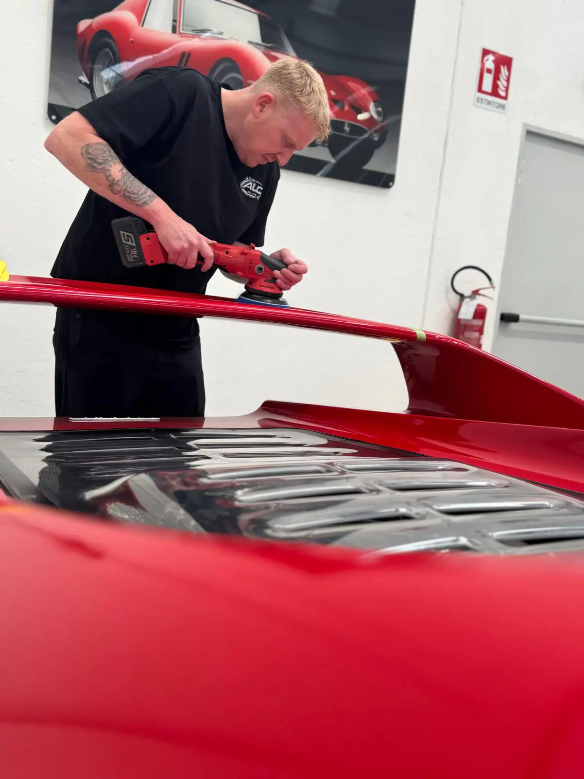 Founder Jonty polishing an exotic red sports car