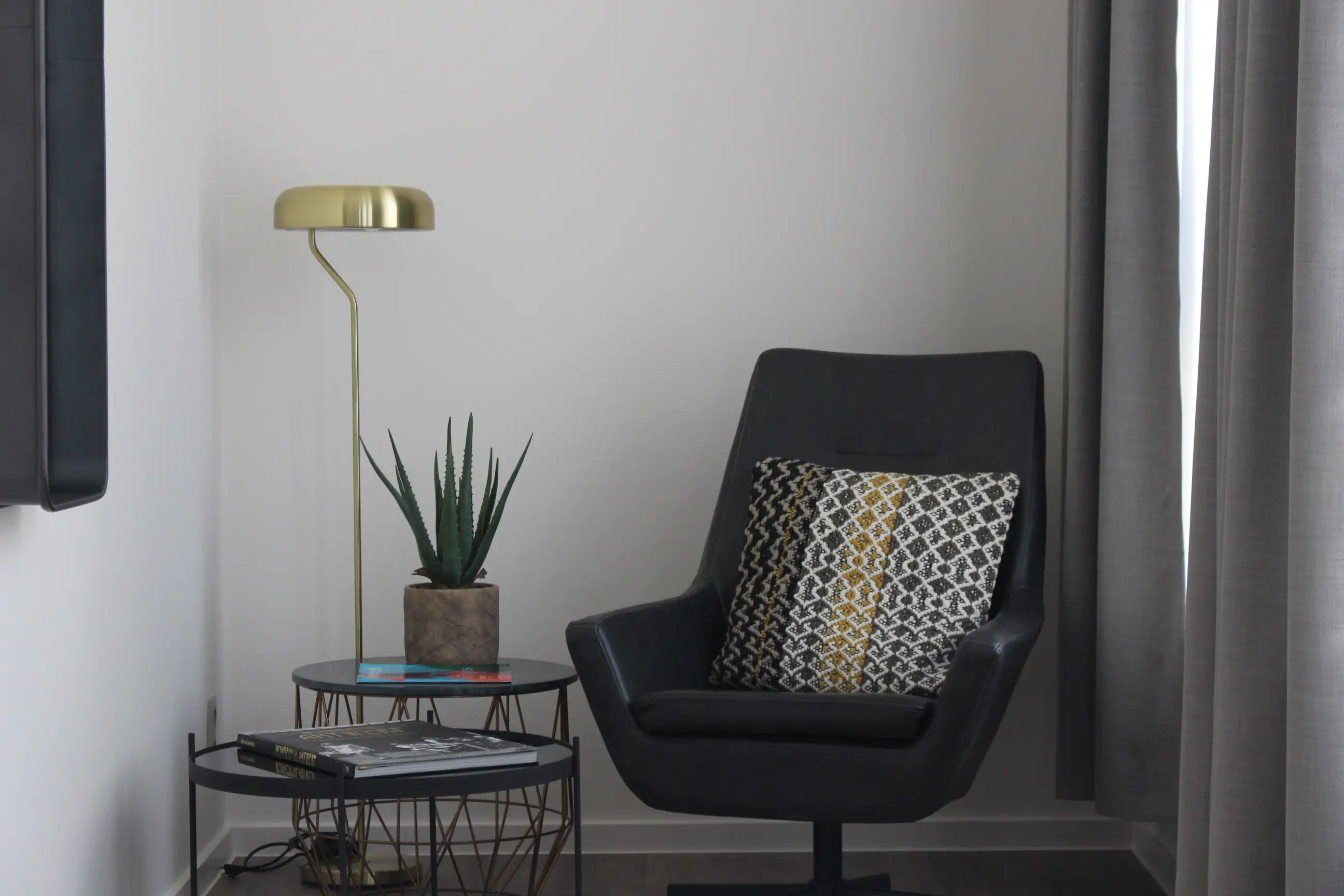 Brown armchair with honeycomb pillow by bright window