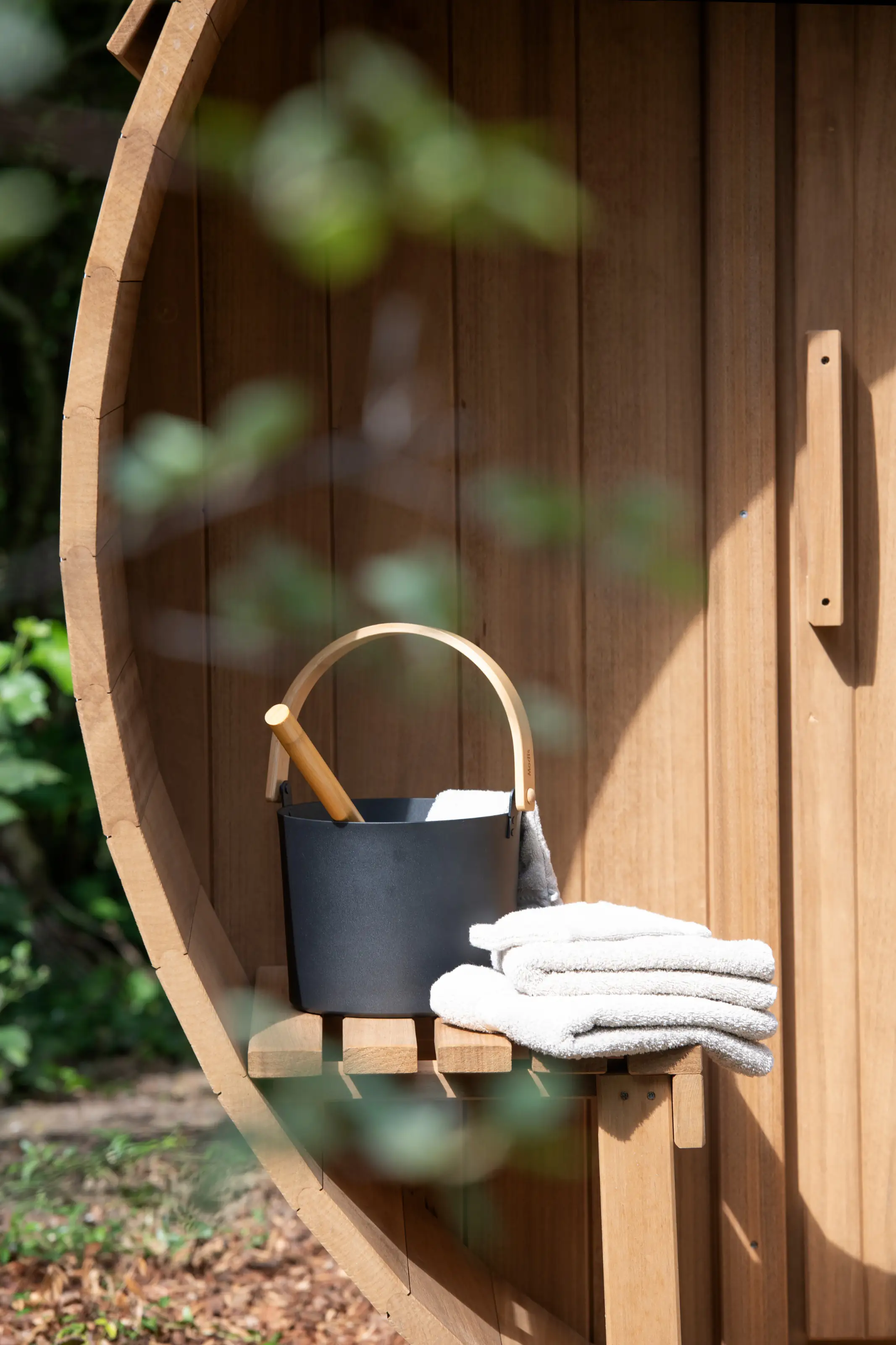 Close-up van de sauna ingang met houten emmer en handdoeken