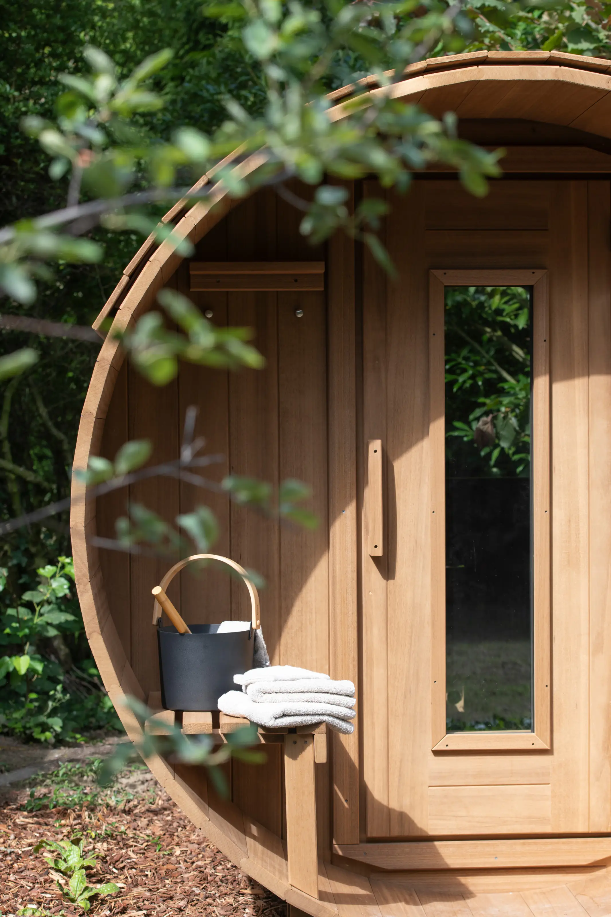 Warm houten sauna exterieur met badlinnen en emmer