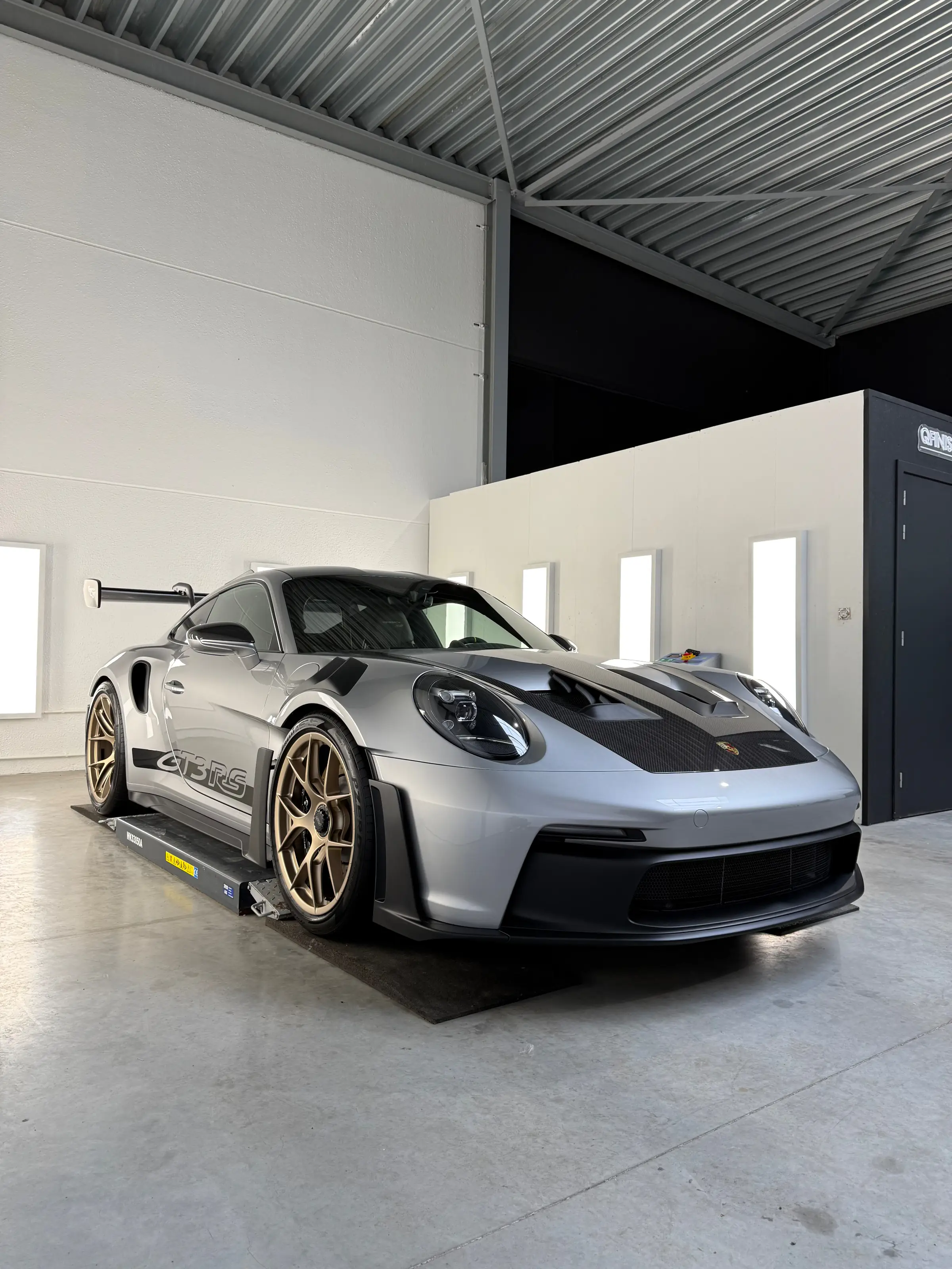 Donkerblauwe BMW in QFINISH detailingstudio onder dramatische verlichting