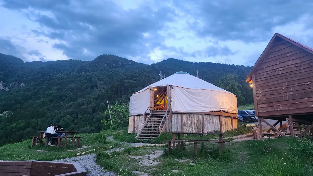 Glamping Tago retreat at twilight with glowing yurts against misty mountains