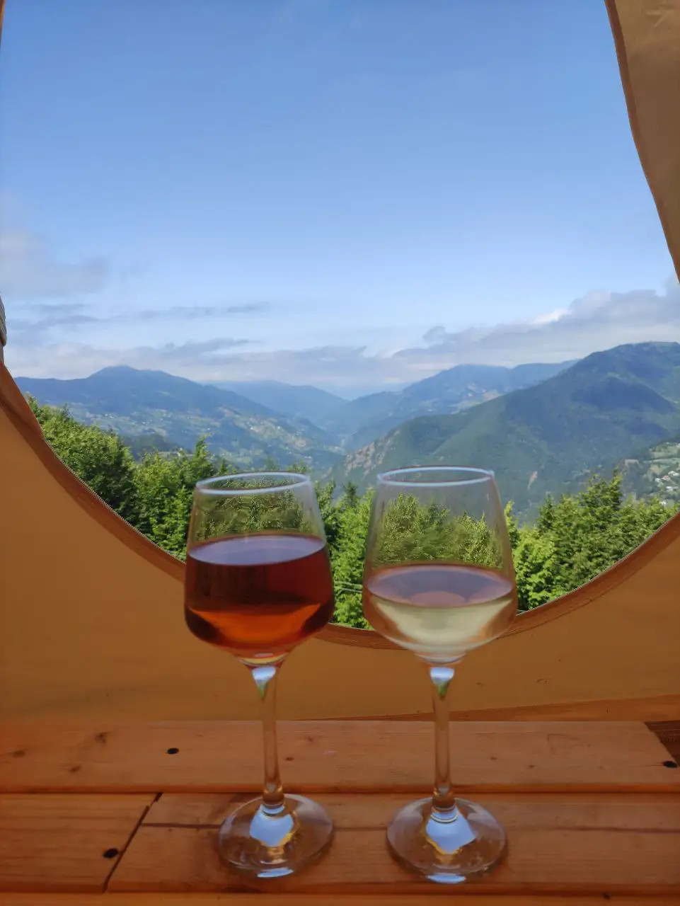 Wine glasses in front of yurt opening with mountain view